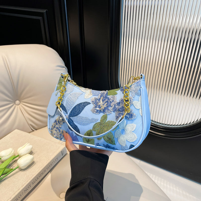Elodie floral sequin shoulder bag in blue — on model