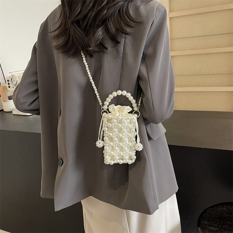 Perla faux-pearl mini crossbody bag in ivory — on model, back view