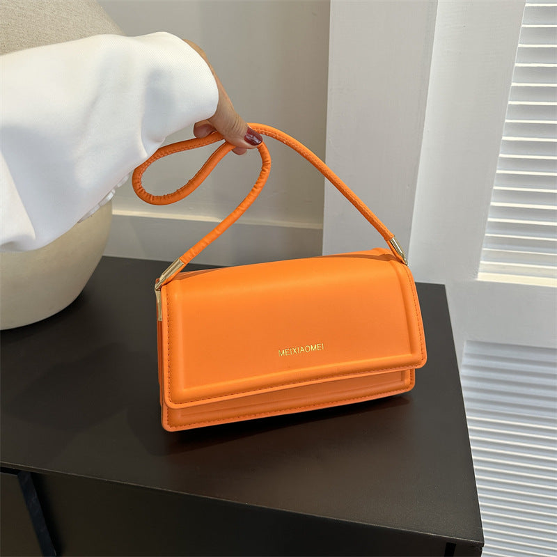Harriet minimalist structured shoulder bag in orange — on model