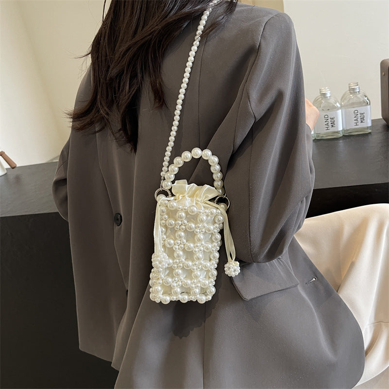 Perla faux-pearl mini crossbody bag in ivory — on model, side view