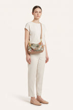Elodie floral sequin shoulder bag in Brown — on model