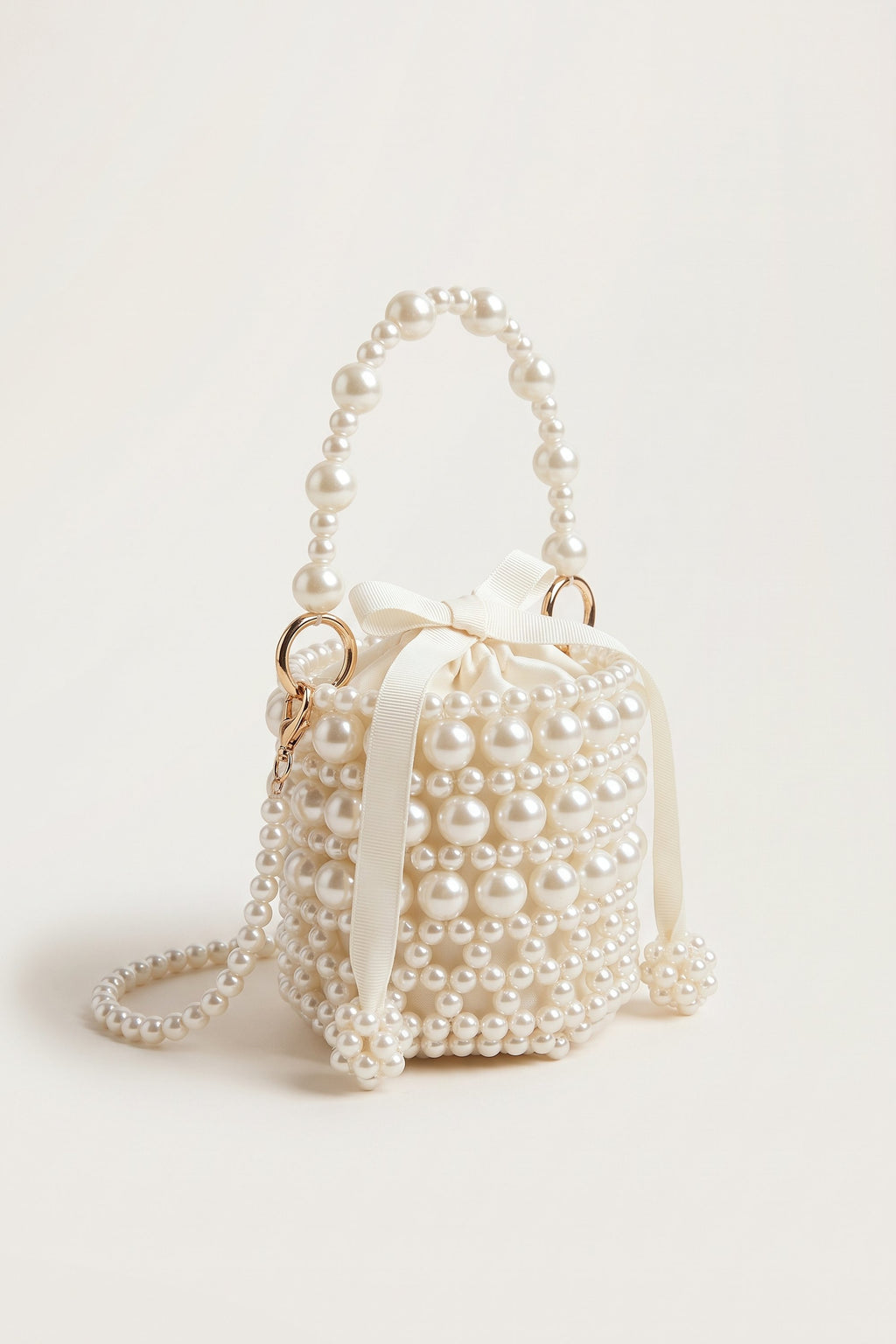 Isla faux-pearl bucket bag in ivory — three-quarter view