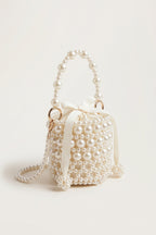 Isla faux-pearl bucket bag in ivory — three-quarter view