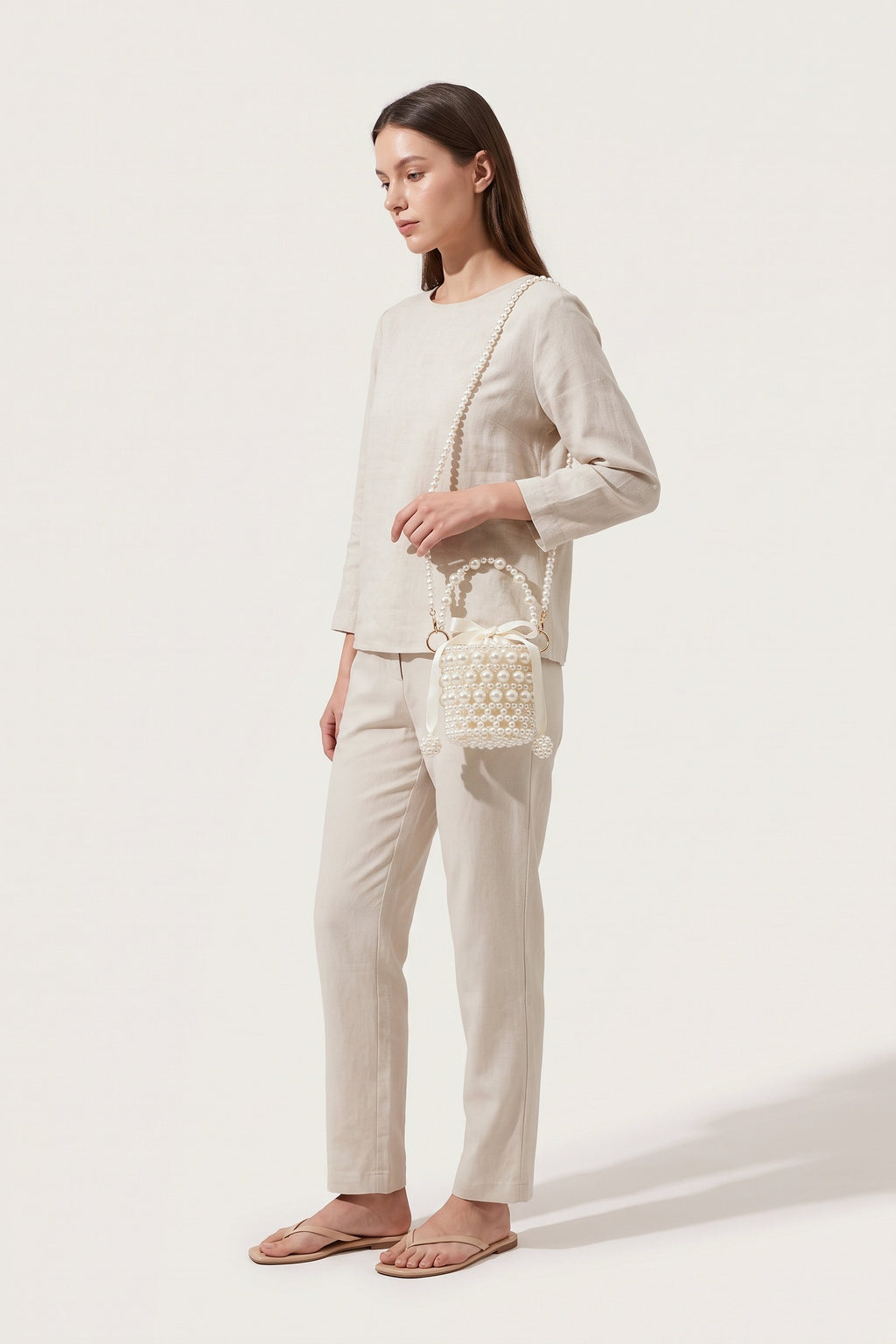 Isla faux-pearl bucket bag in ivory — on model